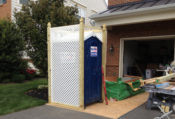 Portable toilet behind lattice for remodelers
